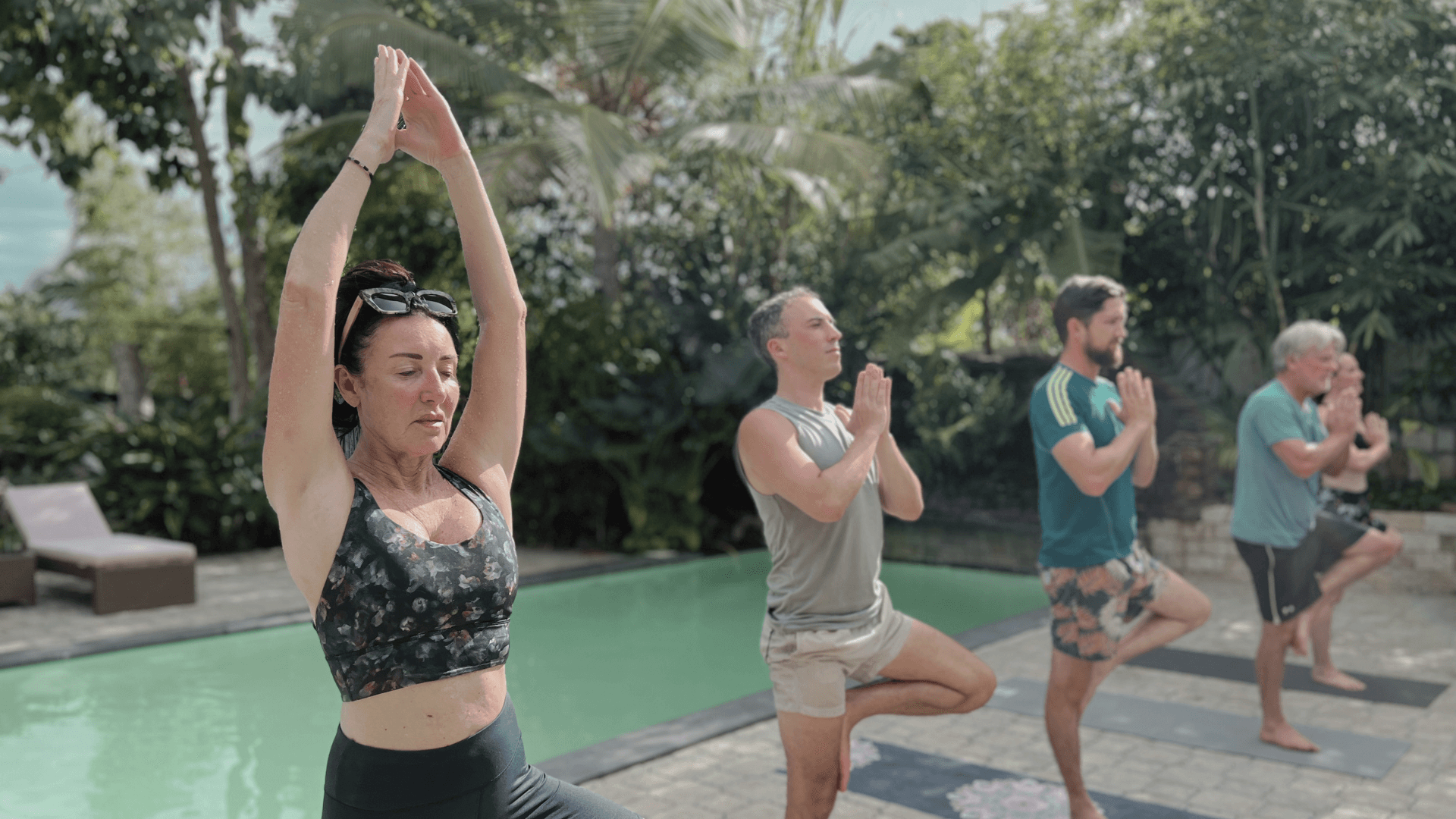 Private group yoga class by a swimming pool